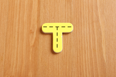 T, spell by woody puzzle letters with woody backgroundの写真素材