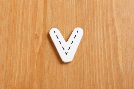 V, spell by woody puzzle letters with woody backgroundの写真素材