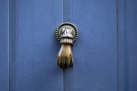 Blue door with a door handle in the shape of a handの写真素材