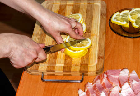 A woman is cutting a lemonの写真素材