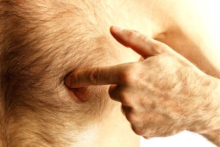 Young man pointing at his abs isolated on white background