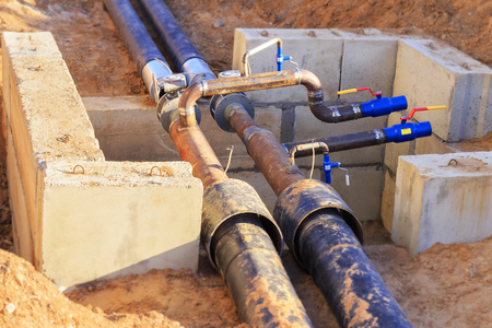 The process of installation of the distribution unit heating network. Frame for connecting pipes in the trench of sand.の写真素材