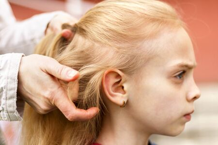 Woman brushing her daughter hair outdoors. jeansの写真素材