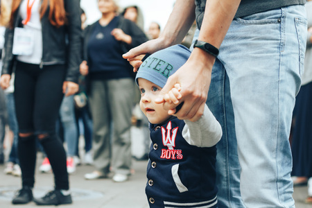 MINSK, BELARUS.JULY 29 2017 Beautiful boy on a walk in the city with his parents in a fashionable clothes. father holds his handのeditorial素材