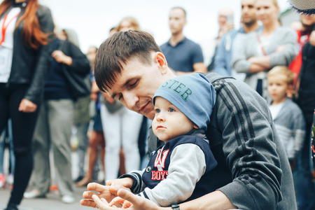 MINSK, BELARUS.JULY 29 2017 Beautiful boy on a walk in the city with his parents in a fashionable clothes. father holds his handのeditorial素材