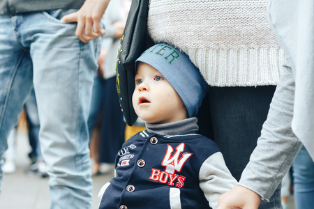 MINSK, BELARUS.JULY 29 2017 Beautiful boy on a walk in the city with his parents in a fashionable clothes. father holds his handのeditorial素材