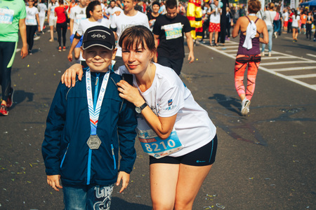 MINSK, BELARUS.September 10 2017 Minsk half-marathon in 2017 Woman and boy with a medal posing in...