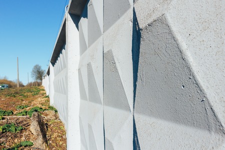 White concrete fence close-up under a blue skyの写真素材