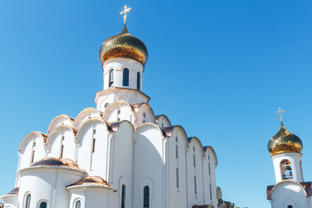 Eastern orthodox crosses on gold domes cupolas againts blue sky with clouds