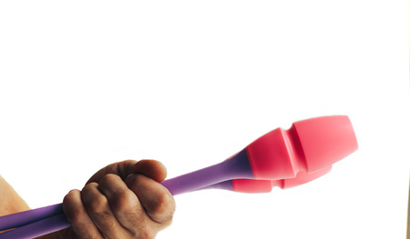 man's hand holds maces for rhythmic gymnastics
