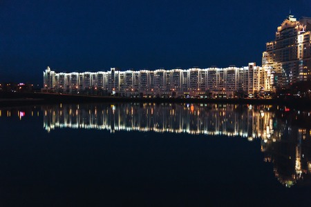 Urban buildings on the river bank. Reflection in waterの写真素材