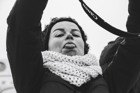 Minsk, Belarus. March 8, 2018 Women's Race Public action Women against violence Girl girl photographer shows tongue outdoorsのeditorial素材