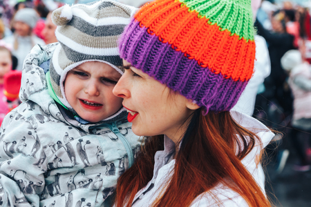 Minsk, Belarus. March 8, 2018 Women's Race Public action Women against violence Girl with baby on hands stands outdoorsのeditorial素材