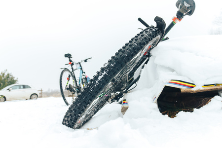 Bicycle lying on the snow the wheel in focusの写真素材