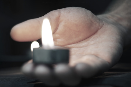 Memorial Day International Holocaust Remembrance Day On the day of the memory of the dead a hand holds a candle Close upの写真素材