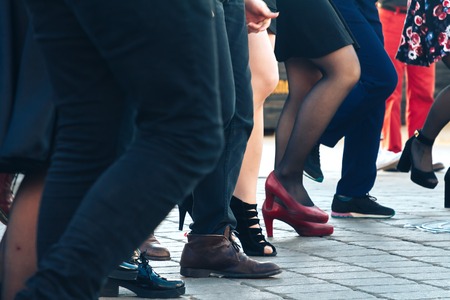 Young and beautiful actors are dancing on the street.