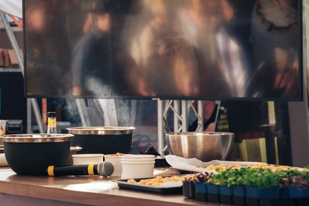 A place to demonstrate the art of the kitchen. Hanging the big screen lies the microphone the food is smokingの写真素材