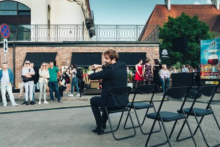 May 25, 2019 Minsk Belarus Street festivities in the evening city A man shows a car ride pantomime in front of people under a blue skyのeditorial素材
