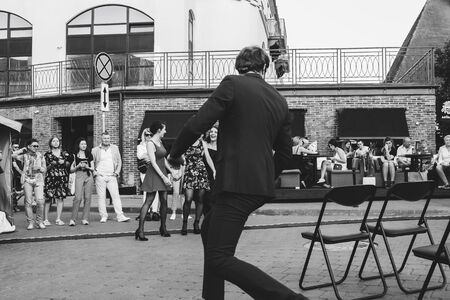 May 25, 2019 Minsk Belarus Street festivities in the evening city A man shows a theatrical performance on the street Black and white imageのeditorial素材
