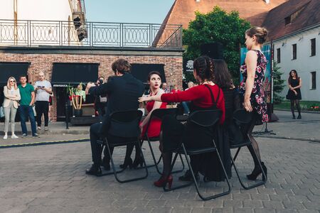 May 25, 2019 Minsk Belarus Street festivities in the evening city Artists play a role when they pretend to go by car sitting on chairs in the squareのeditorial素材
