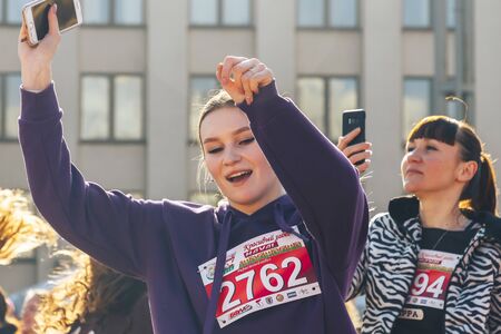 May 25, 2019 Minsk Belarus Street festivities in the evening city Two athletes warm up on the street before the raceのeditorial素材
