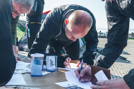 October 6, 2018 Novogrudok Belarus Castle Road Men fill in the consent to participate in the marathonのeditorial素材
