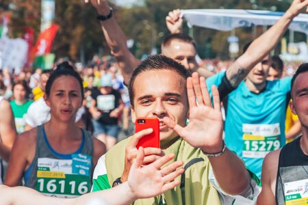 September 9, 2018 Minsk Belarus Half Marathon Minsk 2018 A man with a phone runs a marathon among joyful athletesのeditorial素材