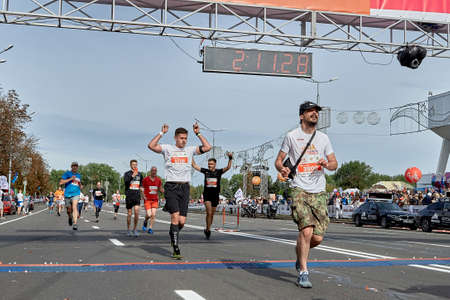 September 15, 2019 Minsk Belarus Marathon runners celebrate crossing the finish line with their hands raisedのeditorial素材