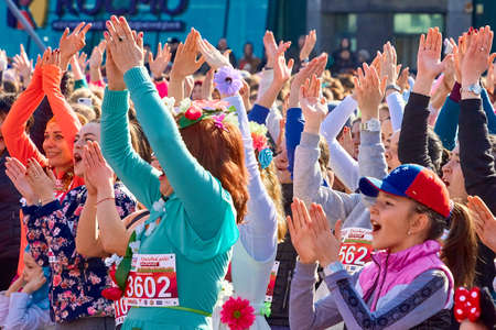March 8, 2019 Minsk Belarus Women's Day Race on March 8.Beautiful women and girls in festive carnival costumes celebrate with their hands raised at a street concertのeditorial素材
