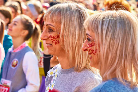 March 8, 2019 Minsk Belarus The inscription, a beauty run on the faces of cheerful twins standing in the square.のeditorial素材