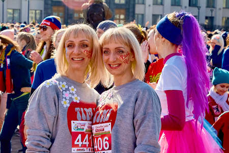 March 8, 2019 Minsk Belarus The inscription, a beauty run on the faces of mature happy twins standing among the crowd of girlsのeditorial素材