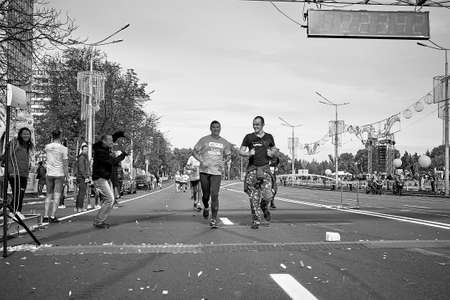 September 15, 2019 Minsk Belarus A marathon race in which two happy participants run to the finish line. A man takes photos of athletes on his phoneのeditorial素材