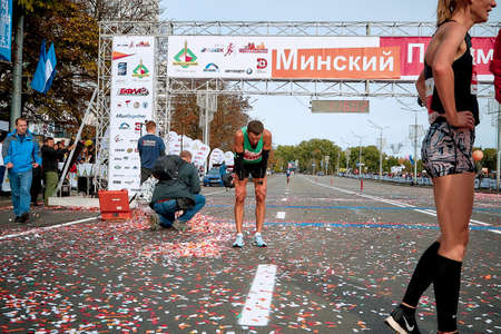 September 15, 2018 Minsk Belarus Half Marathon Minsk 2019 Marathon runner bent over trying to catch his breath after the finishのeditorial素材