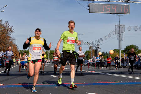 September 15, 2018 Minsk Belarus Half Marathon Minsk 2019 Two cheerful runners cross the finish line Muscular runner out, doing handstandのeditorial素材