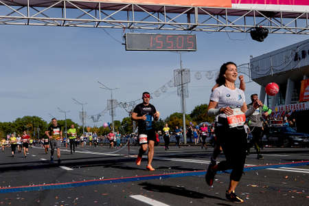 September 15, 2019 Minsk Belarus Beautiful runners running after finish line on paved road.のeditorial素材