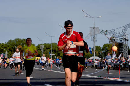 September 15, 2018 Minsk Belarus Half Marathon Minsk 2019 Young athlete runner looks at a modern smart clock after Minsk Half Marathonのeditorial素材