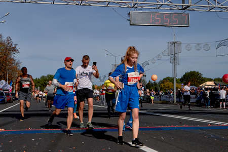 September 15, 2019 Minsk Belarus Many fast runners running after the finish line marathon. Healthy lifestyle.のeditorial素材