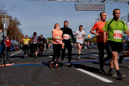 September 15, 2019 Minsk Belarus Many cheerful runners running after the finish line marathon. Healthy lifestyle.のeditorial素材