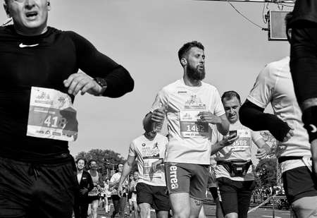 September 15, 2019 Minsk Belarus Many runners running cross the finish line marathon.Athlete with a beard close-up. Healthy lifestyle.のeditorial素材