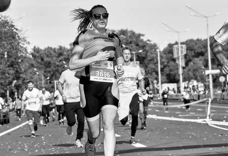 September 15, 2019 Minsk Belarus In black and white, beautiful woman runs a marathon. Healthy...