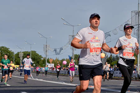 September 15, 2018 Minsk Belarus Half Marathon Minsk 2019 Man and woman athletes on the asphalt road in the cityのeditorial素材