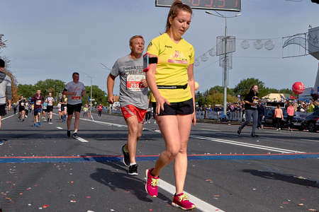 September 15, 2019 Minsk Belarus Man and woman cross the finish line of a marathon on a sunny autumn dayのeditorial素材