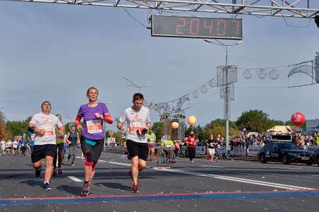 September 15, 2018 Minsk Belarus Half Marathon Minsk 2019 Group of runners cross the finish line marathon on paved road in town.のeditorial素材