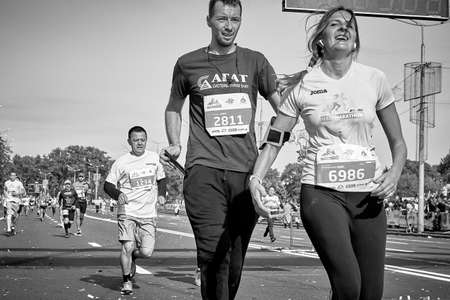 September 15, 2018 Minsk Belarus Half Marathon Minsk 2019. In black and white, cheerful man and woman athletes running on paved road in townのeditorial素材