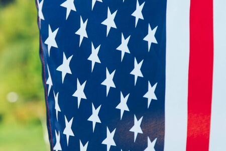Us flag hanging in front of the forestの写真素材
