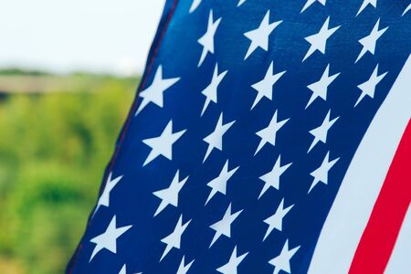 Us flag hanging in front of the forestの写真素材