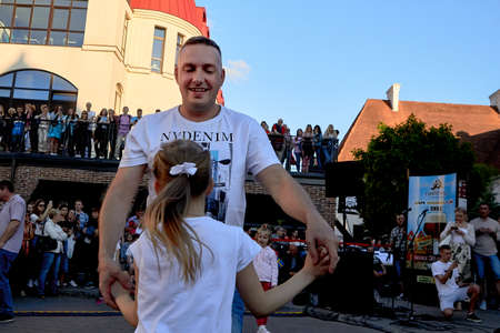 June 1, 2019 Minsk Belarus Happy father and daughter holding hands against the blue sky on the streetのeditorial素材