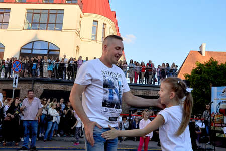 June 1, 2019 Minsk Belarus Happy father and daughter dance holding hands against the blue sky on the streetのeditorial素材