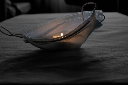 Abstract image of a candle flame burning in a protective maskの写真素材