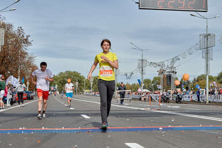 September 15, 2019 Minsk Belarus A tired woman crosses the finish line of a marathonのeditorial素材